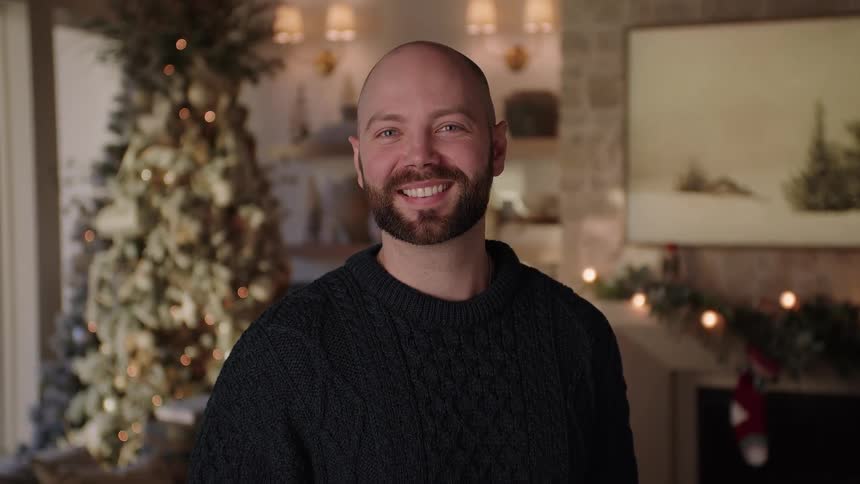 A man smiling while standing in the living room