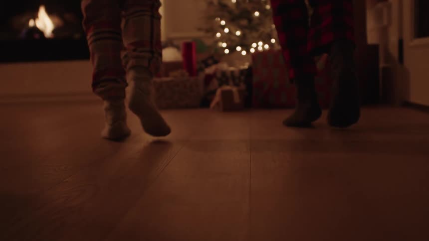 Siblings running to open presents at christmas morning