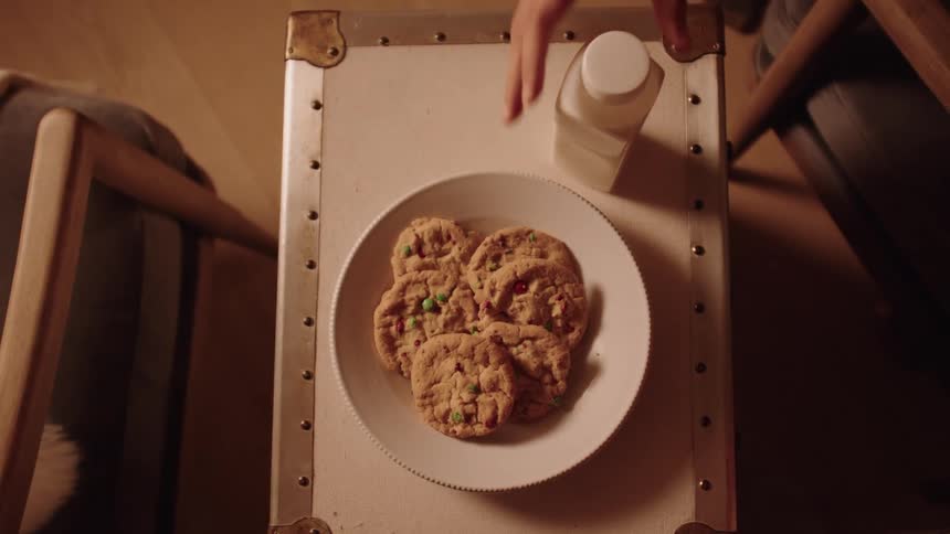 Placing plate of cookies and a bottle of milk on a coffee table