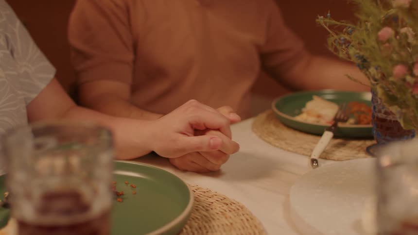 Couple sitting at the table holding hands