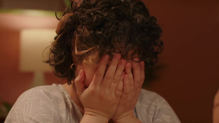 Closeup of a womans face laughing in embarrassment