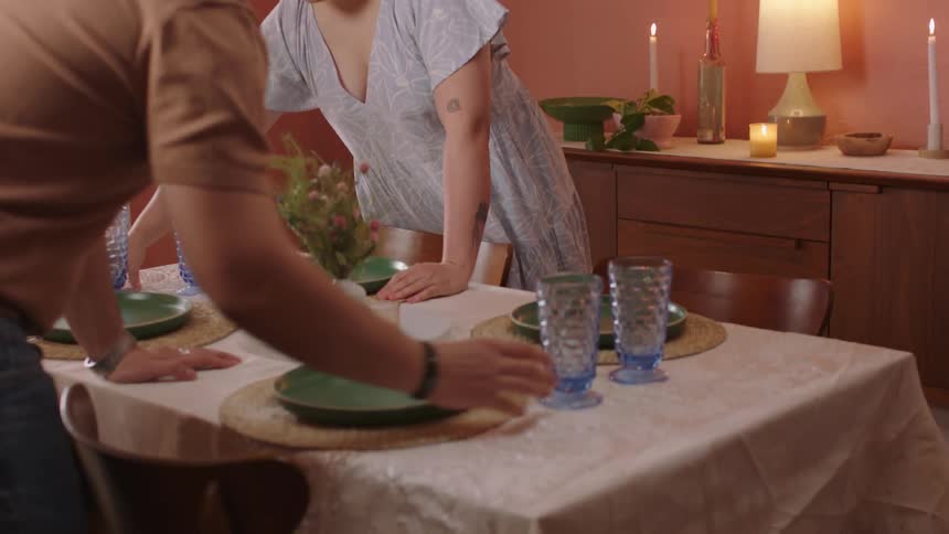A happy couple setting a dining table