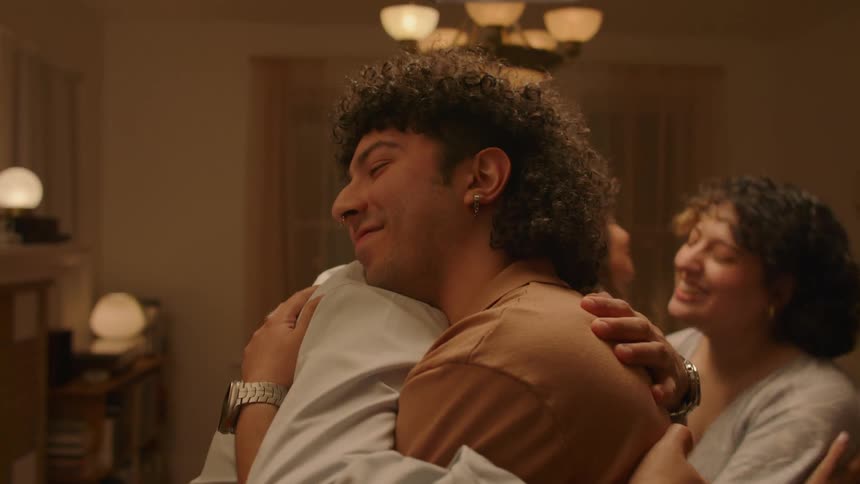 Men and women share hugs while smiling indoor at night