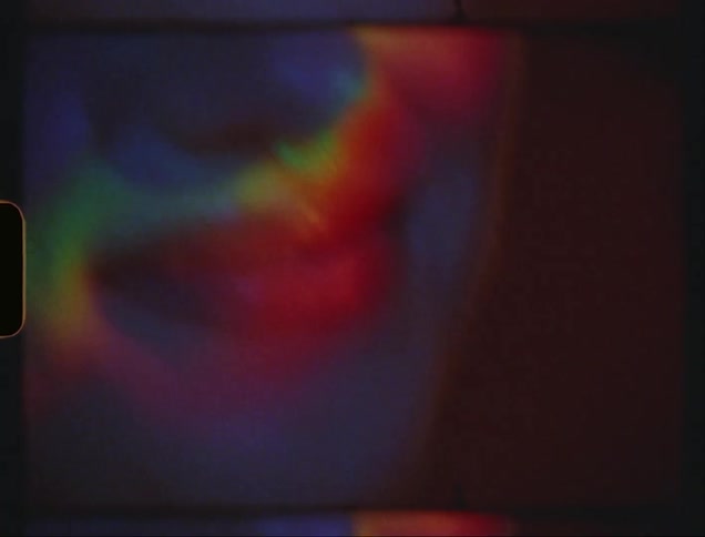 Closeup of a womans face illuminated with the colors of the rainbow