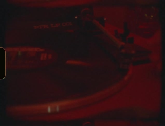 Closeup of a persons hand putting a vinyl record to use