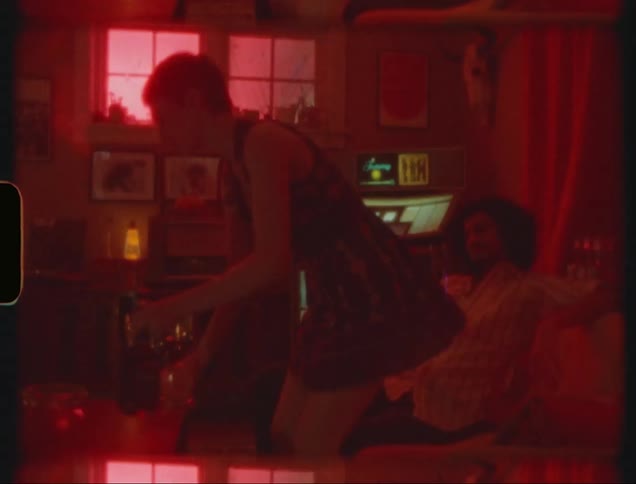 Woman taking champagne from glasses and sitting next to her boyfriend on the sofa