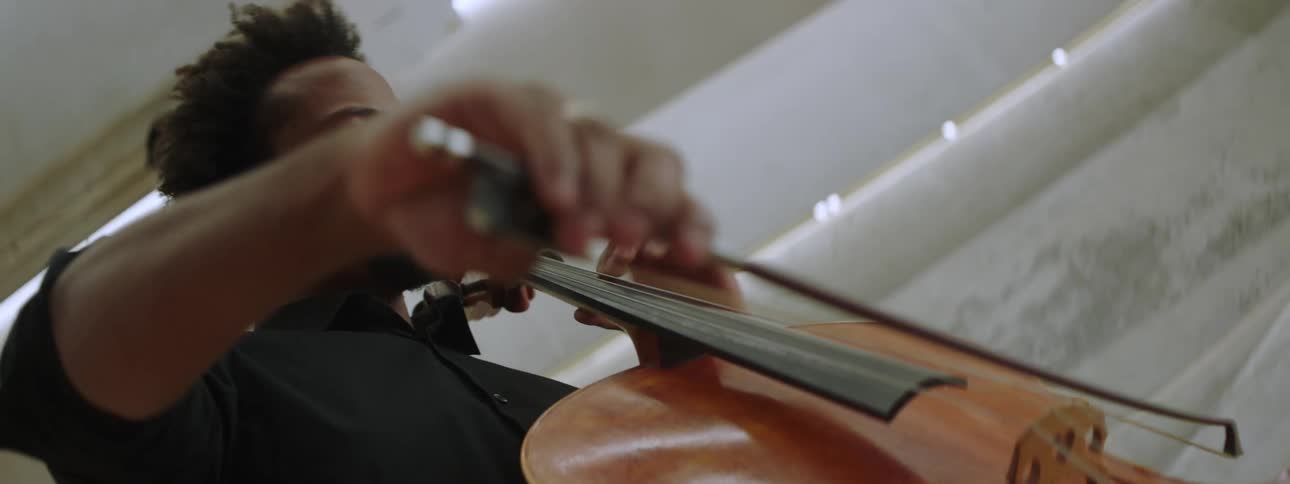 Young man playing the cello on a theatre stage