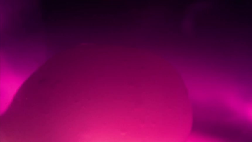 Dense and abstract balls of neon purple color falling