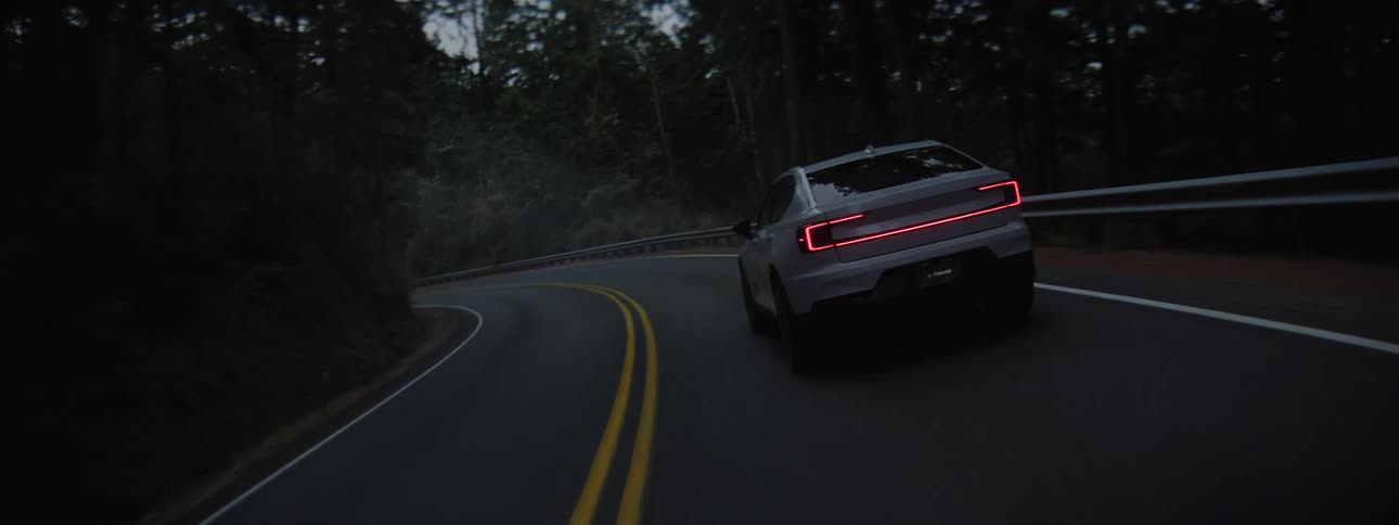 EV Polestar driving through smoke and trees at dawn