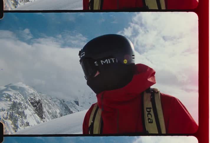 Person involved with winter sports stands on snow covered mountain during winter on a cloudy day