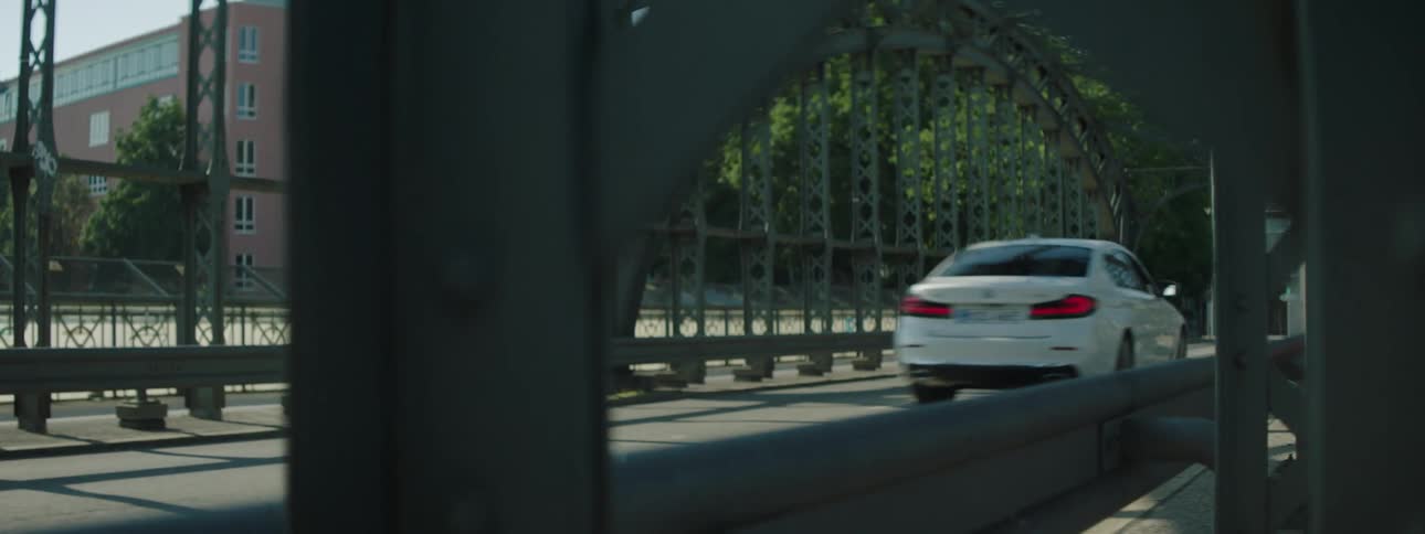 White sedan car passing on a bridge