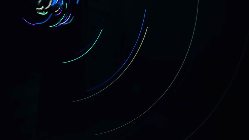 Colorful arcs or light flashing and whipping in a circle against a black background