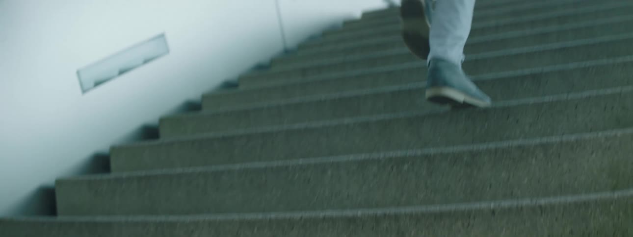 A person climbing a staircase leading to an exit