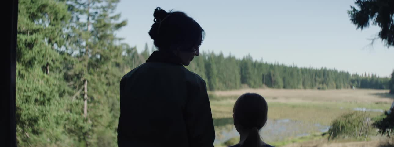 A woman and a girl admiring a field in the forest