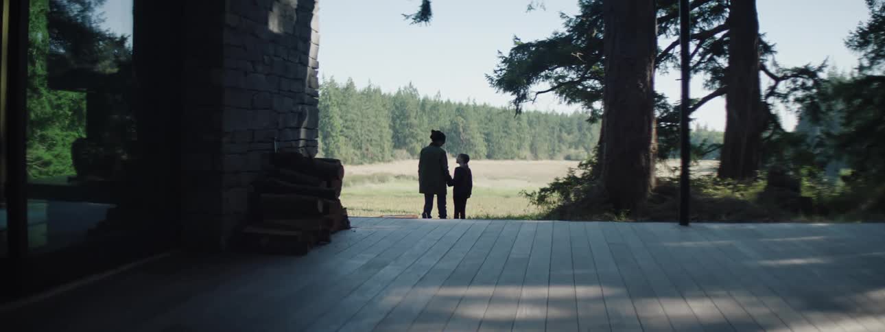 A woman and a daughter admiring the forest landscape on a sunny day