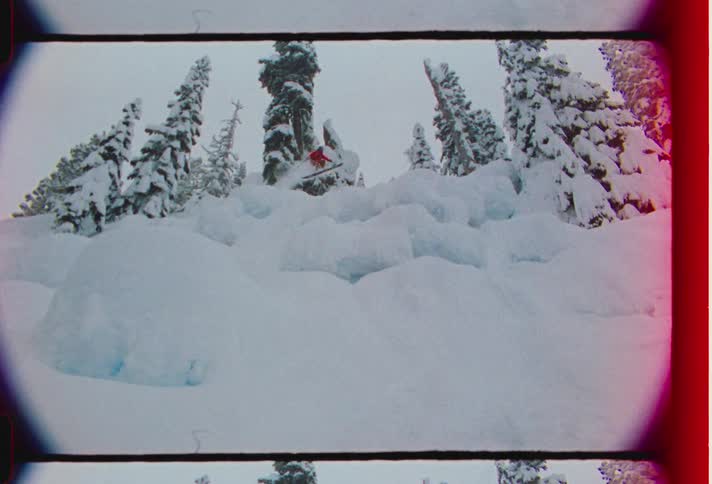 Person descending a winding mountain and snowboarding