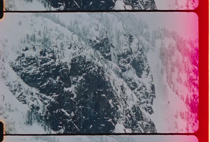 A steep slope of a rocky mountain is coated in a layer of snow