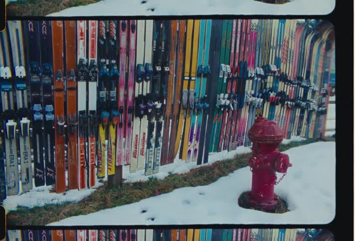 A row of skis are against the wall