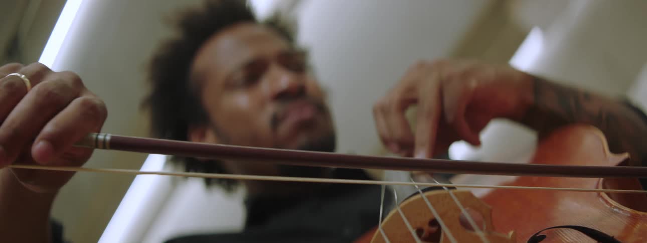 A close up of an inspired musician playing the cello