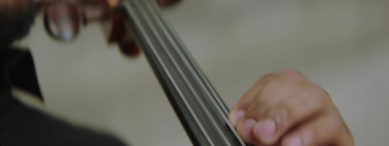 A man playing a cello in a room