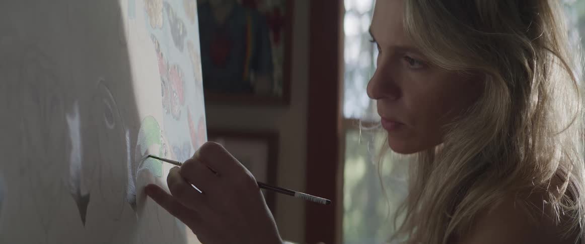 Portrait of a woman painting on a board