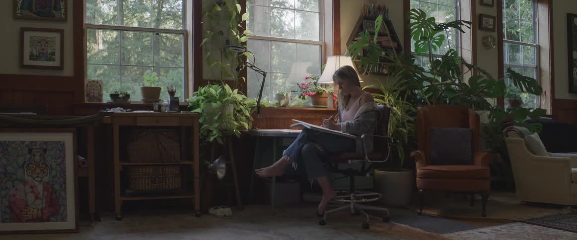 Woman sitting in a chair in a room drawing
