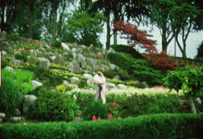 An older couple kissing in a scenic garden