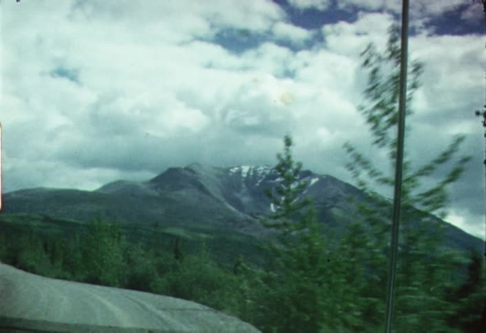 A vehicle travels along a narrow mountain road