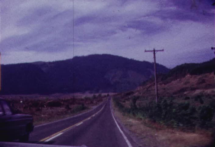 The road ahead is empty with one car passing by