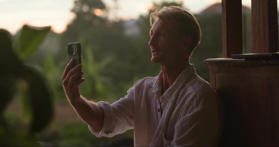 Man sitting talking on selfie on cell phone