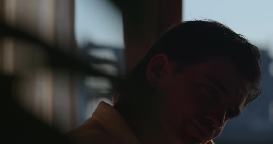 A man looking like hes thinking and sad sitting in a room