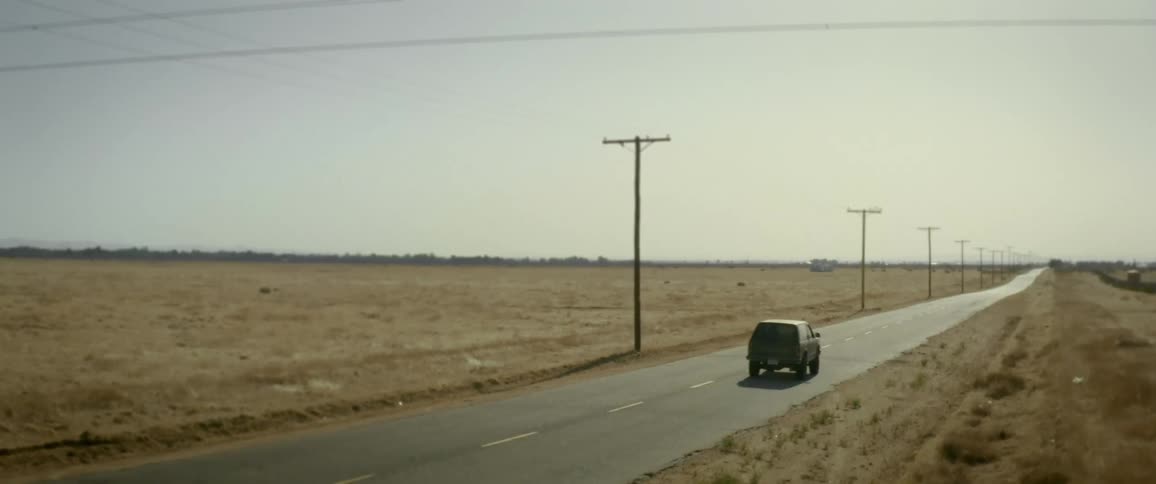 Truck traveling on a road and a half in field