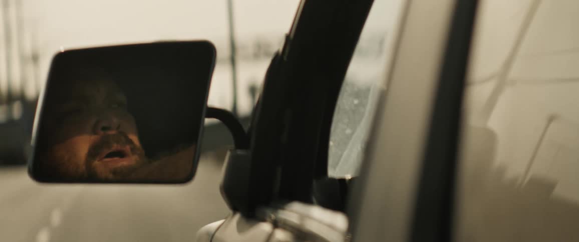 Man driving a pickup truck while smoking