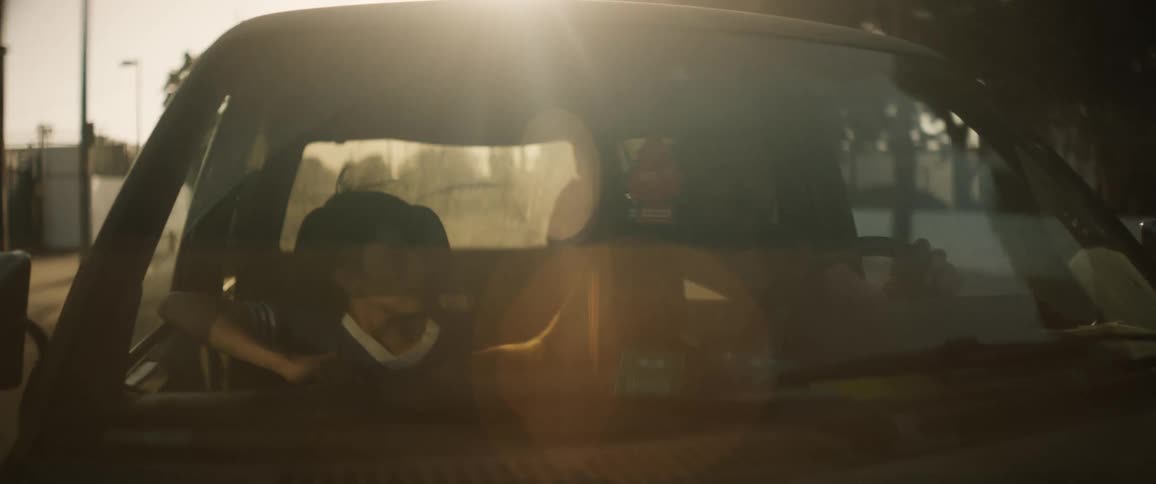 View of the front of the vehicle with a boy and an adult with a moving car