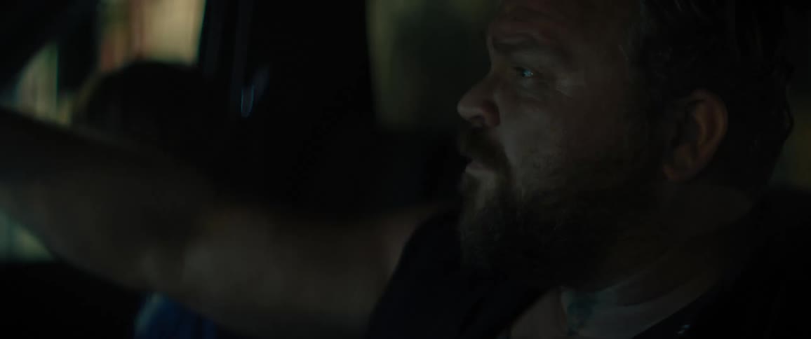 Portrait of a man inside his vehicle adjusting the rear view mirror