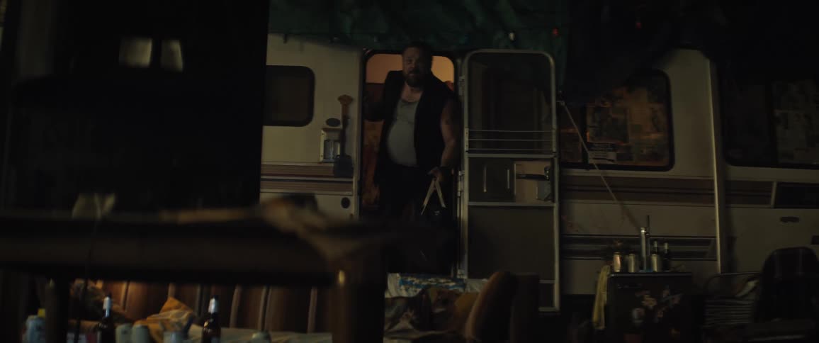 A man carrying a bag leaving a trailer at night