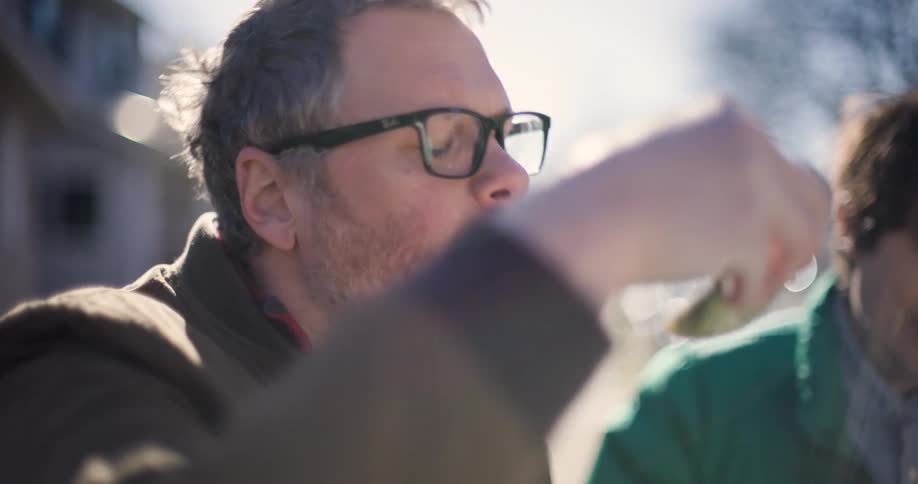 A man eats an oyster outside