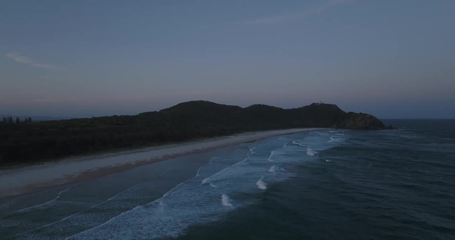 Multiple waves wash upon the sandy beach lining this coast