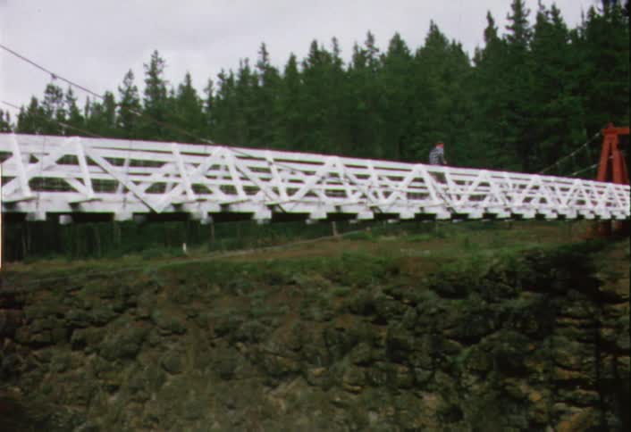 A boy running across a rickety bridge