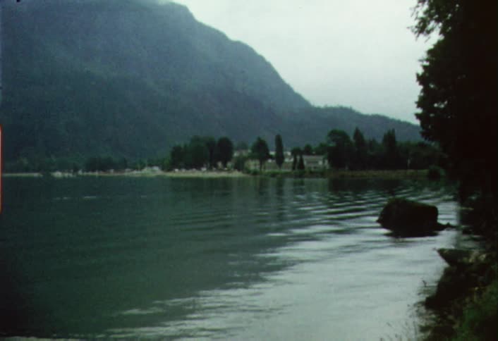 A boy skips a rock on the lake ahead
