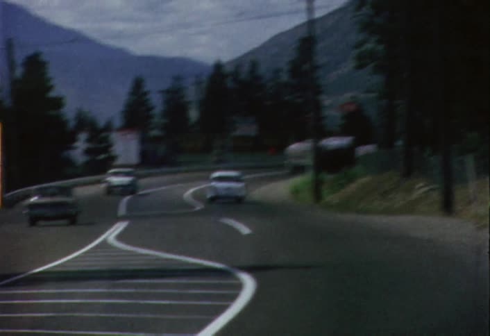 Moving view of several vehicles driving on a winding road