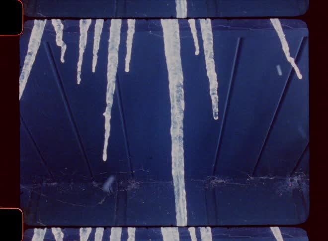 Precipitation falls while long icicles thaw on building overhang