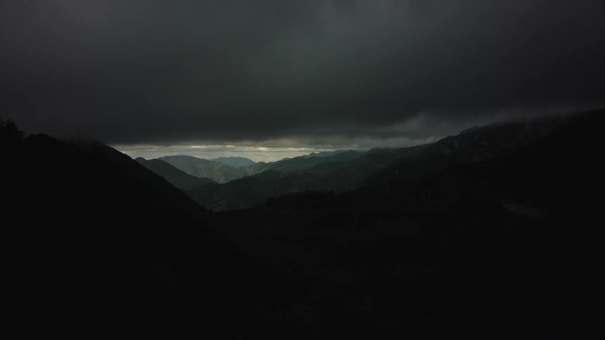 Aerial of a mountain range during cloudy dusk