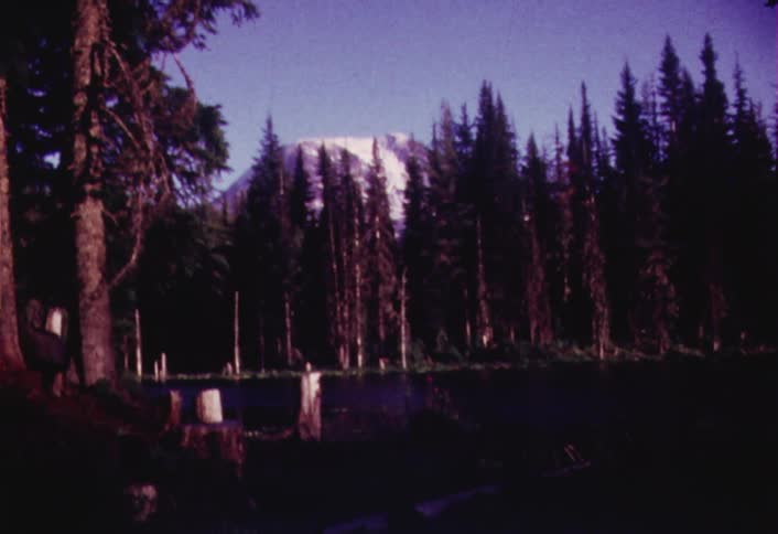 Zooming view of a mountain with trees in the foreground on a clear day
