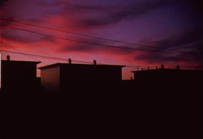 Colorful cloudy sunset behind small buildings