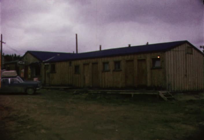 Cars parked in front of a wooden cabin