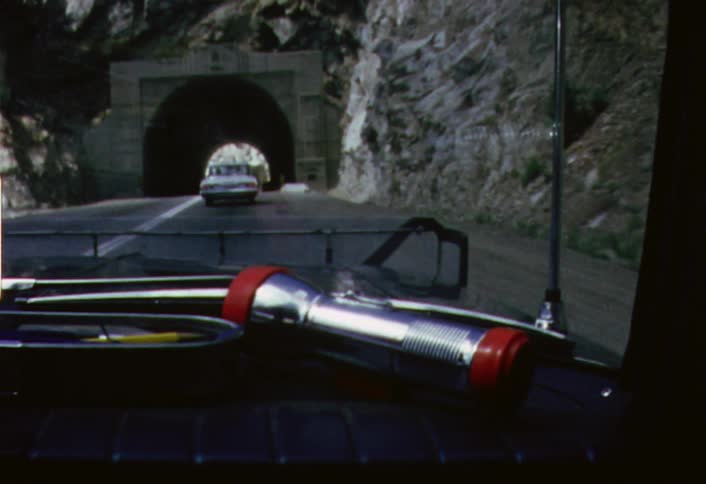 Traffic moving into a tunnel as seen through a moving windshield