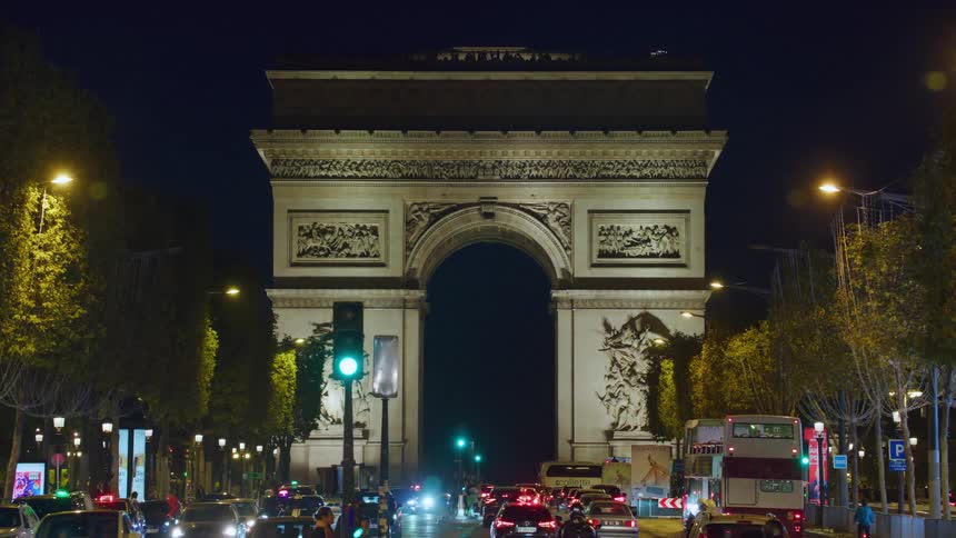 Vehicles move on a road that passes under an arched structure