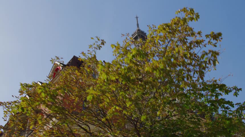 Upward view of residential buildings and the eiffel tower on a cloudless blue sky day