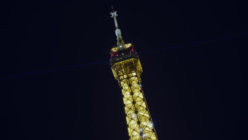 The tower is lit up with a spotlight at the top